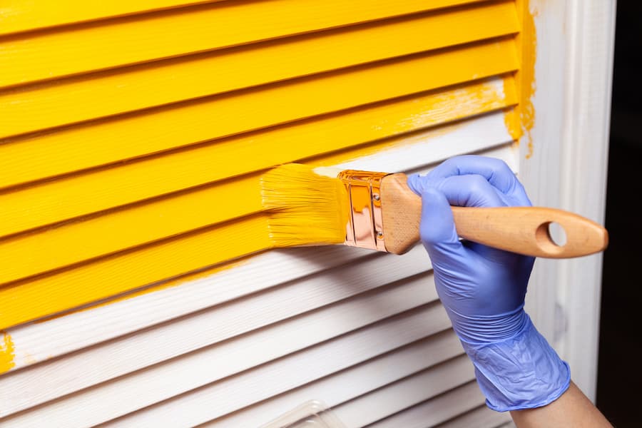 Person Painting Slats Yellow